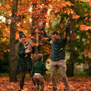 Family in late winter light throwing leaves in the air with theif canberra family photographer.
